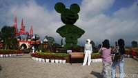 Di pintu masuk yang sekaligus tempat pembelian tiket masuk, berdiri megah bangunan kastel, selanjutnya disambut dengan deretan tanaman dan ada patung Mickey Mouse ukuran besar.