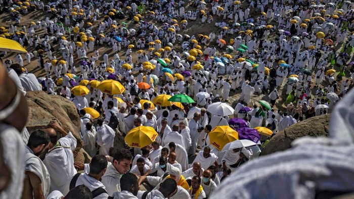 Jemaah Mulai Padati Padang Arafah Jelang Wukuf, Begini Suasananya Muslim pilgrims climb Mount Arafat, also known as Jabal al-Rahma (Mount of Mercy), to perform their morning prayers, southeast of the holy city of Mecca, during the climax of the Hajj pilgrimage, early on July 8, 2022. (Photo by Delil SOULEIMAN / AFP) (Photo by DELIL SOULEIMAN/AFP via Getty Images)