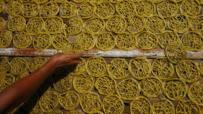 Kriuk Gurih Mi Krupuk Tegal Dimulai dari Sini Pekerja menjemur kerupuk mie di Desa Harjosari, Kabupaten Tegal, Jawa Tengah, Kamis (7/7/2022). Perajin kerupuk setempat mengeluhkan harga bahan baku kerupuk mie dua pekan terakhir naik seperti tepung tapioka naik dari Rp8.000 menjadi Rp10.000 per kilogram mengakibatkan harga kerupuk mie naik dari Rp13.000 menjadi Rp15.000 per kilogram. ANTARA FOTO/Oky Lukmansyah/rwa.