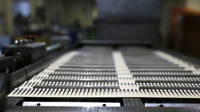 Lebih Dekat dengan Nittosha, Korek Api Terakhir dari Jepang Jun Onishi, the fifth-generation firstborn, the great great grandson of the founder and the current chief executive’s son, stands beside a production machine at a Nittosha factory in Himeji, Japan, Wednesday, June 29, 2022. Nittosha, a small Japanese manufacturer, is stopping the production of matchbooks. The company, which employs 130 people, is a testament to the hard work and dedication at small and medium-size companies that are the backbones of large economies, including the U.S. and Japan. (AP Photo/Yuri Kageyama)