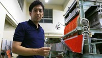 Jun Onishi, anak sulung generasi kelima, cicit dari pendiri dan putra kepala eksekutif saat ini, berdiri di samping mesin produksi di pabrik Nittosha di Himeji, Jepang.