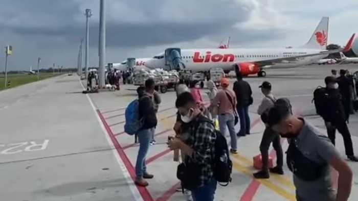 Penumpang pesawat menunggu bus penjemputan di Bandara Internasional Sultan Hasanuddin.