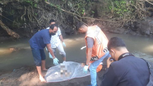 Polisi melakukan identifikasi pada tubuh mayat bayi laki-laki yang ditemukan di gundukan pada aliran sungai atau Tukad Yeh Sungi, Banjar Dakdakan, Desa Abiantuwung, Kecamatan Kediri, Tabanan, Bali, Jumat (8/7/2022).