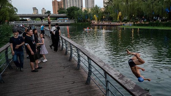 BEIJING, CHINA - JULY 07: People use paddle boards, or SUP, on the Liangma River on a hot summer day on July 7, 2022 in Beijing, China. Parts of northern China are enduring one of the worst heatwaves in decades with temperatures reaching 40 degrees Celsius (104 degrees Fahrenheit) in some areas. (Photo by Kevin Frayer/Getty Images)