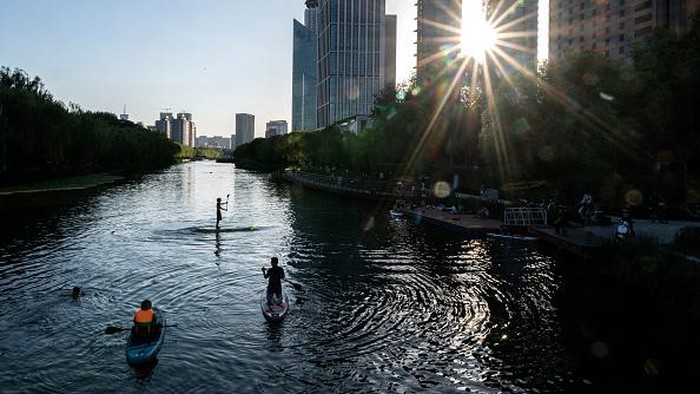 BEIJING, CHINA - JULY 07: People use paddle boards, or SUP, on the Liangma River on a hot summer day on July 7, 2022 in Beijing, China. Parts of northern China are enduring one of the worst heatwaves in decades with temperatures reaching 40 degrees Celsius (104 degrees Fahrenheit) in some areas. (Photo by Kevin Frayer/Getty Images)