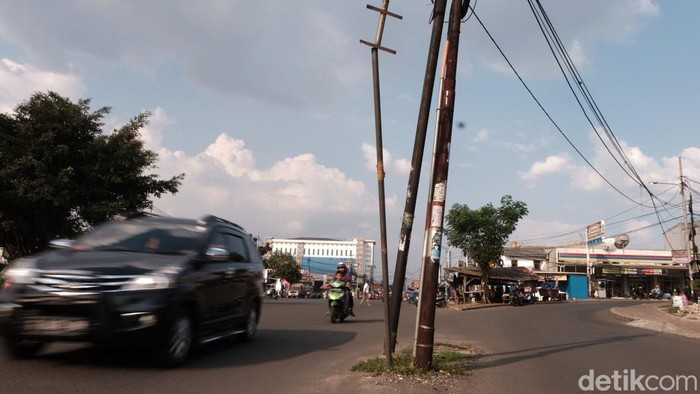 Ada 2 buah tiang berdiri di tengah jalan di Perempatan Viktor, Tangsel, Banten. Pengendara diimbau hati-hati di jalan.