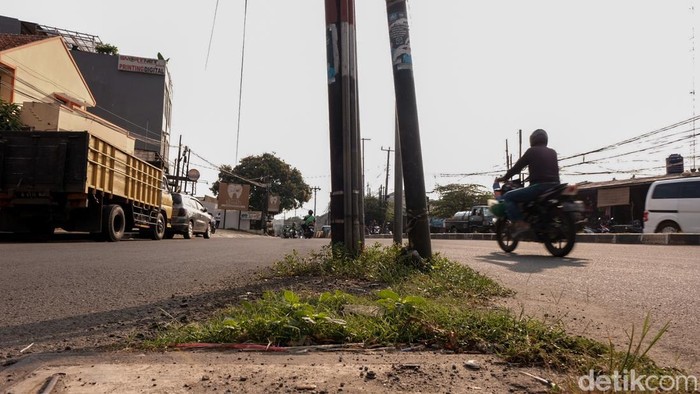 Ada 2 buah tiang berdiri di tengah jalan di Perempatan Viktor, Tangsel, Banten. Pengendara diimbau hati-hati di jalan.
