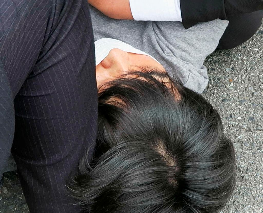 Tangkapan layar ini menunjukkan tersangka, bernama Tetsuya Yamagami  yang diyakini telah menembak mantan Perdana Menteri Jepang Shinzo Abe, yang ditahan oleh petugas polisi di Nara, Jepang, Jumat (8/7/2022). (Kyodo/via REUTERS)