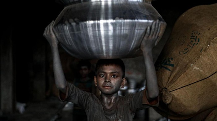 1241763962 A child works inside a kitchen utensils factory at Shyampur in Dhaka, Bangladesh on July 4, 2022. (Photo by Kazi Salahuddin Razu/NurPhoto via Getty Images)