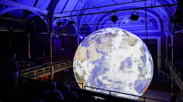HARTLEPOOL, ENGLAND - JULY 06: Visitors come to see the Gaia artwork by UK artist Luke Jerram as it is displayed inside Hartlepool Town Hall Theatre on July 06, 2022 in Hartlepool, England. The installation is part of the launch for the Hartlepool Waterfront Festival, a two-day festival of maritime creativity that is due to take place in Hartlepool Marina this weekend. (Photo by Ian Forsyth/Getty Images)