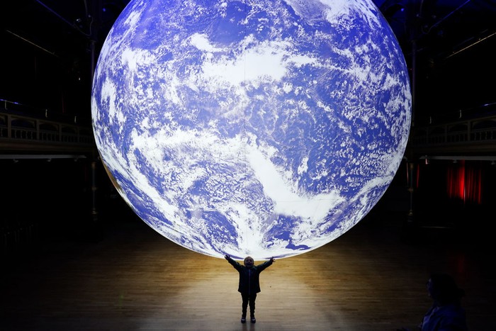 HARTLEPOOL, ENGLAND - JULY 06: Visitors come to see the Gaia artwork by UK artist Luke Jerram as it is displayed inside Hartlepool Town Hall Theatre on July 06, 2022 in Hartlepool, England. The installation is part of the launch for the Hartlepool Waterfront Festival, a two-day festival of maritime creativity that is due to take place in Hartlepool Marina this weekend. (Photo by Ian Forsyth/Getty Images)