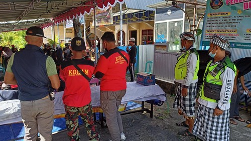 Pecalang dari Banjar Adat Dauh Peken-Pengabetan, Desa Dauh Peken, bersama Kokam bekerja sama mengatur kelancaran pembagian daging kurban di Gedung Dakwah Muhammadiyah, Sabtu (9/7/2022).