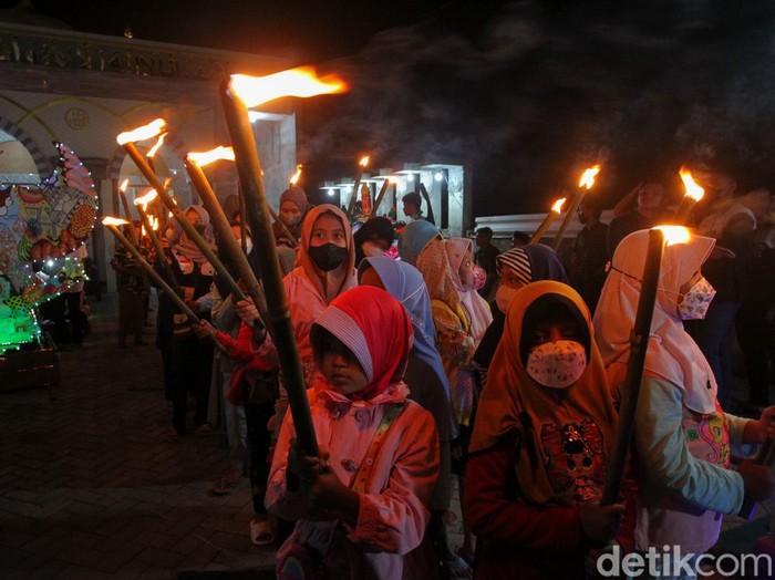 Sejumlah anak tampak mengikuti takbiran keliling menggunakan obor sambut Idul Adha 1443 H, di Dusun Ngaran, Margokaton, Seyegan, Sleman, Yogyakarta, Jumat (8/7/2022).