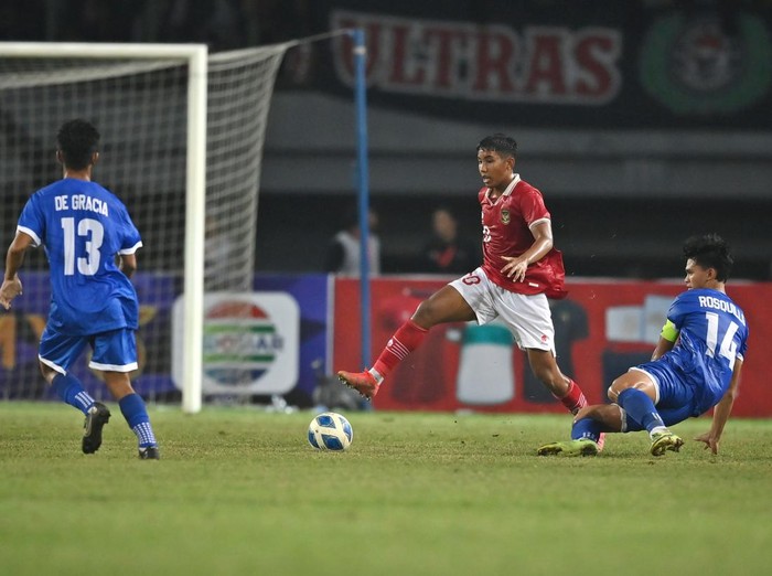 Pesepak bola Tim Nasional Indonesia U-19 Razzaa Fachrezi (tengah) mengecoh pesepak bola Tim Nasional Filipina U-19 Jaime Domingo (kanan) dalam laga penyisihan Grup A Piala AFF U-19 2022 di Stadion Patriot Candrabhaga, Bekasi, Jawa Barat, Jumat (8/7/2022). Indonesia memenangkan pertandingan tersebut dengan skor 5-1. ANTARA FOTO/Aditya Pradana Putra/aww.