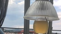 Seorang pelanggan kaget bahwa minumannya ditaruh dalam wadah berbentuk bohlam lampu. Terlihat minuman koktail itu tergantung agak tinggi dan sulit untuk diminum. Foto: ranker.com / Josh Gu