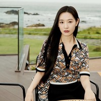 Berlatar pemandangan pantai, Kim Ji Won terlihat elegan memakai Monogram Wool Blend Jacquard Polo Shirt. Dia tak perlu memakai aksesori untuk terlihat stunning. Foto: dok. Burberry