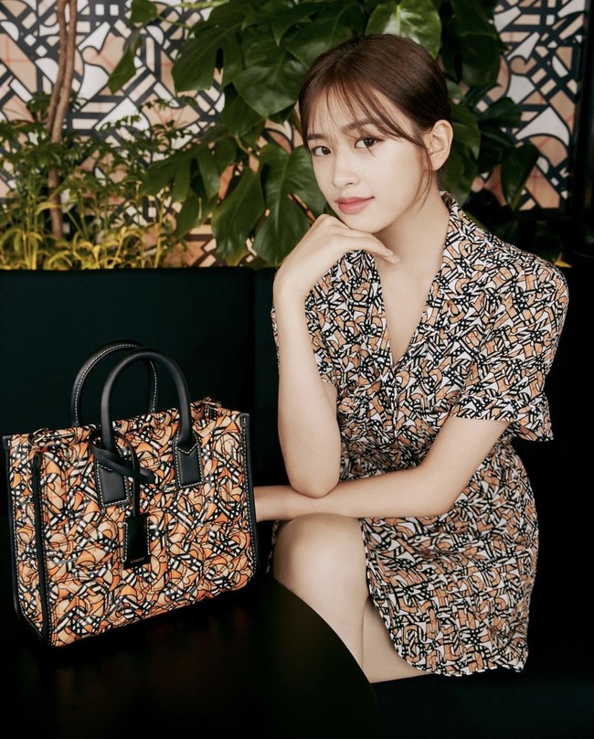 Yujin IVE terlihat kalem dan anggun memakai Short-sleeve Monogram Print Silk Shirt Dress dari Burberry. Seperti Chaewon, dia juga memakai koleksi Freya Tote Bag. Foto: dok. Burberry