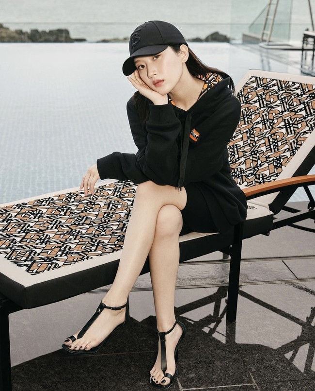 Simpel ala cewek mamba. Moon Ga Young memakai hoodie, biker pants, baseball cap, dan strap sandals serba hitam. Foto: dok. Burberry