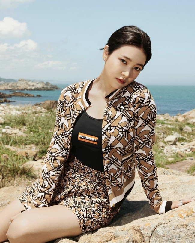 Yeri Red Velvet terlihat lebih edgy dalam balutan swimsuit dan printed shorts yang dipadukan dengan Monogram Wool Blend Jacquard Cardigan. Foto: dok. Burberry