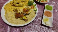 Begini penyajian nasi mandhi di restoran ini. Disajikan bersama daging kambing panggang, serta sambal cabe merah dan hijau. Foto: detikFood/Yenny Mustika Sari