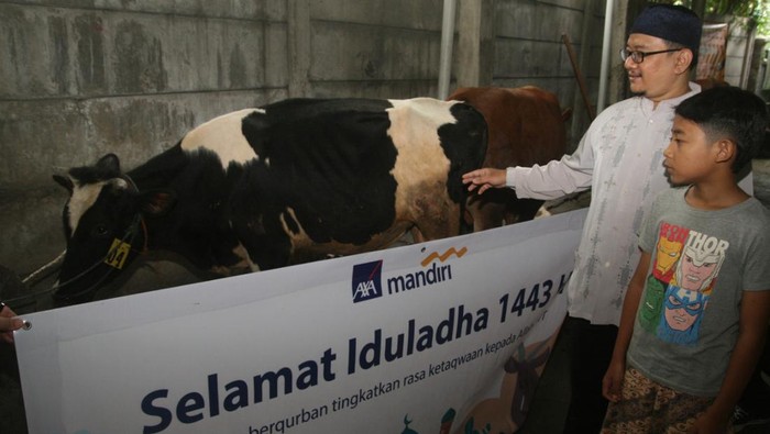 Direktur Kepatuhan PT AXA Mandiri Financial Services (AXA Mandiri) Rudy Kamdani (kiri) menyerahkan secara simbolis hewan qurban kepada pengurus Masjid Jami’ Roudhotul Falah Ustadz Asad di Jakarta, Sabtu (9/7/2022). Sebagai bagian dari wujud kepedulian kepada masyarakat, selain penyerahan hewan qurban, AXA Mandiri baru-baru ini melakukan kegiatan pembersihan Sungai Ciliwung di Bogor, Jawa Barat, serta penyelamatan hutan bakau di Pulau Pari Kepulauan Seribu, Jakarta Utara. Kegiatan  pelestarian lingkungan tersebut juga merupakan bagian strategi keberlanjutan dan peningkatan layanan kepada nasabah.
