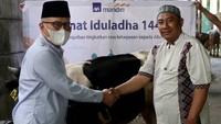 Direktur Kepatuhan PT AXA Mandiri Financial Services (AXA Mandiri) Rudy Kamdani (kiri) menyerahkan secara simbolis hewan qurban kepada pengurus Masjid Jami’ Roudhotul Falah Ustadz Asad di Jakarta. 