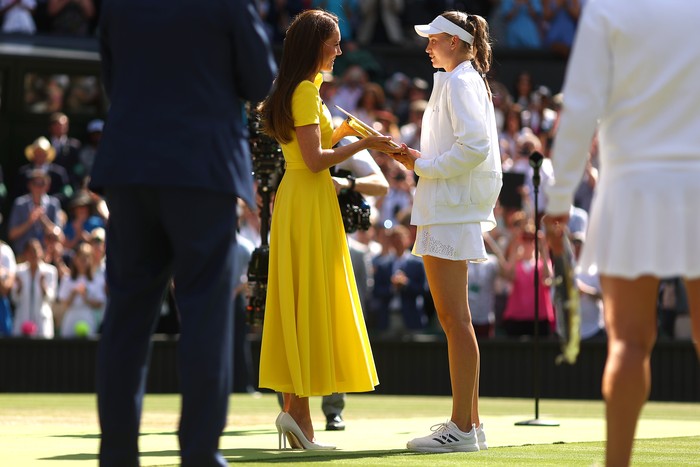 Kate Middleton di Wimbledon 2022 Britains Catherine, Duchess of Cambridge gives the Venus Rosewater Dish trophy to Kazakhstans Elena Rybakina during the podium ceremony after winning the womens singles final tennis match against Tunisias Ons Jabeur on the thirteenth day of the 2022 Wimbledon Championships at The All England Tennis Club in Wimbledon, southwest London, on July 9, 2022. - RESTRICTED TO EDITORIAL USE (Photo by Adrian DENNIS / AFP) / RESTRICTED TO EDITORIAL USE (Photo by ADRIAN DENNIS/AFP via Getty Images)