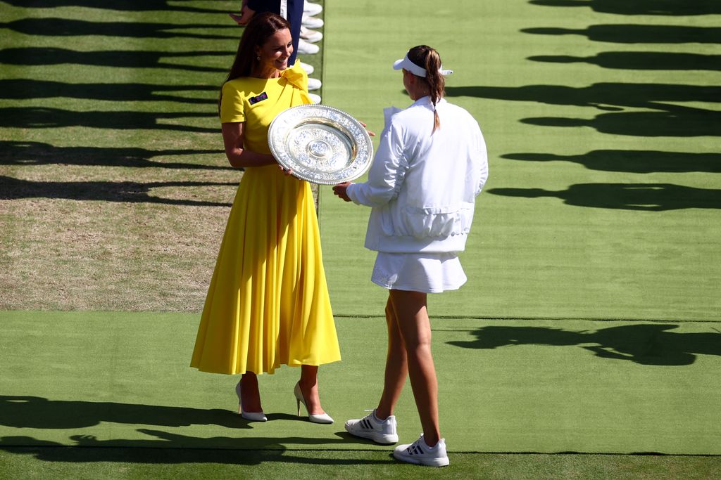 Britain's Catherine, Duchess of Cambridge gives the Venus Rosewater Dish trophy to Kazakhstan's Elena Rybakina during the podium ceremony after winning the women's singles final tennis match against Tunisia's Ons Jabeur on the thirteenth day of the 2022 Wimbledon Championships at The All England Tennis Club in Wimbledon, southwest London, on July 9, 2022. - RESTRICTED TO EDITORIAL USE (Photo by Adrian DENNIS / AFP) / RESTRICTED TO EDITORIAL USE (Photo by ADRIAN DENNIS/AFP via Getty Images)