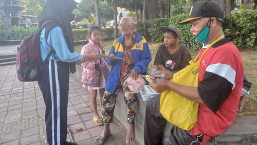 Nyoman Sindri, suami, dan ketiga cucunya saat menjajakan koran bekas di areal Taman Kota Singaraja, Buleleng, Bali, saat Hari Raya Idul Adha, Minggu (10/7/2022).