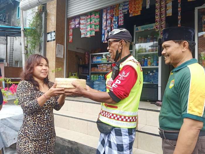 Pihak LDII Bali bersama dengan Pecalang ketika ngejot daging kurban kepada warga lintas agama yang berada di kawasan LDII Bali, di Jalan Padang Griya II No 1 Denpasar, Bali pada Minggu (10/7/2022).