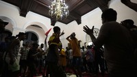 Tak hanya berenang, sejumlah demonstran juga tampak asyik bernyanyi dan menari saat memasuki area kediaman resmi Presiden Sri Lanka yang berada di kawasan Kolombo pada Sabtu (9/7) waktu setempat. (AP Photo/ Eranga Jayawardena).
