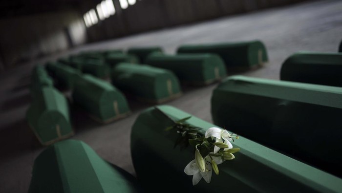 A Muslim man prays next to the coffin of a family member who is among 50 newly identified victims of Srebrenica Genocide in Potocari, Bosnia, Sunday, July 10, 2022. Thousands converge on the eastern Bosnian town of Srebrenica to commemorate the 27th anniversary Monday of Europe’s only acknowledged genocide since World War II. (AP Photo/Armin Durgut)