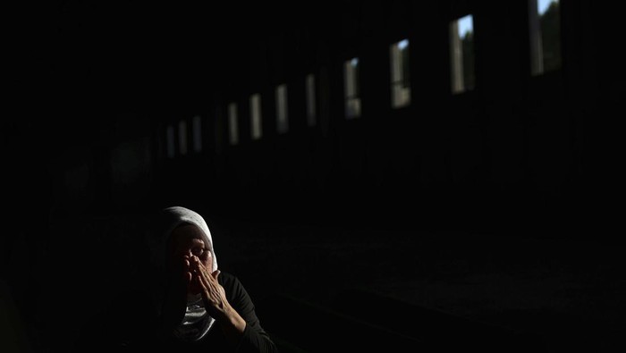 A Muslim man prays next to the coffin of a family member who is among 50 newly identified victims of Srebrenica Genocide in Potocari, Bosnia, Sunday, July 10, 2022. Thousands converge on the eastern Bosnian town of Srebrenica to commemorate the 27th anniversary Monday of Europe’s only acknowledged genocide since World War II. (AP Photo/Armin Durgut)