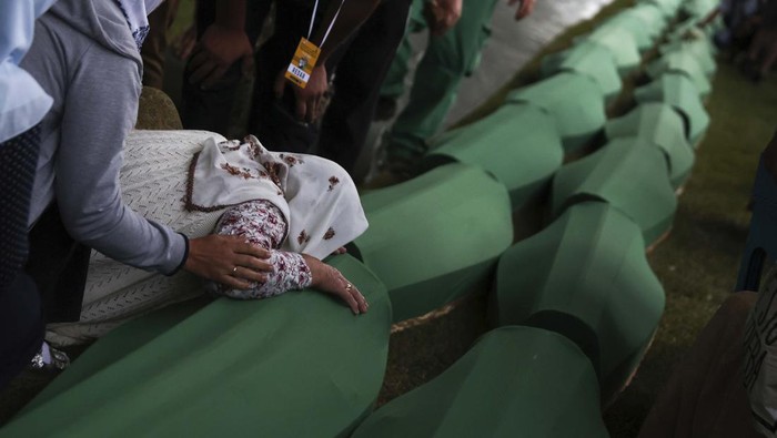 50 Korban Pembantaian Srebrenica Berhasil Diidentifikasi A Muslim man prays next to the coffin of a family member who is among 50 newly identified victims of Srebrenica Genocide in Potocari, Bosnia, Sunday, July 10, 2022. Thousands converge on the eastern Bosnian town of Srebrenica to commemorate the 27th anniversary Monday of Europeβs only acknowledged genocide since World War II. (AP Photo/Armin Durgut)