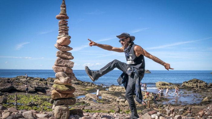 Ada Kejuaraan Susun Batu di Eropa, Unik Banget Competitor Pedro Duran takes part in the 'most stones balanced in 20 minutes' event during the European Stone Stacking Championships 2022 on Eye Cave Beach in Dunbar, East Lothian. The championships are Europe's largest competition for all stone stacking and rock balancing enthusiasts and artists. Picture date: Sunday July 10, 2022. (Photo by Jane Barlow/PA Images via Getty Images)