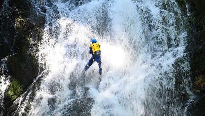 Aksi Menantang Tim SAR China Latihan Evakuasi di Air Terjun YICHUN, CHINA - JULY 09: A volunteer of local Blue Sky Rescue Team takes part in an emergency drill at a waterfall on July 9, 2022 in Yichun, Jiangxi Province of China. (Photo by VCG/VCG via Getty Images)