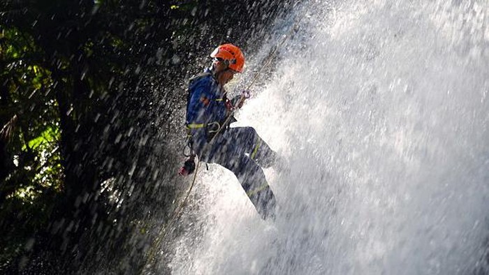 Aksi Menantang Tim SAR China Latihan Evakuasi di Air Terjun YICHUN, CHINA - JULY 09: A volunteer of local Blue Sky Rescue Team takes part in an emergency drill at a waterfall on July 9, 2022 in Yichun, Jiangxi Province of China. (Photo by VCG/VCG via Getty Images)
