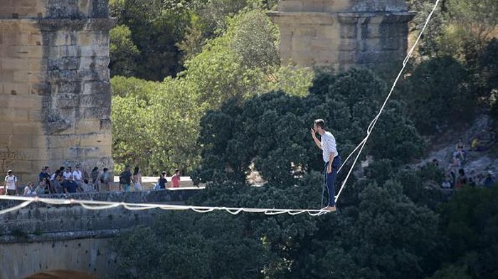 VERS-PONT-DU-GARD, FRANCE - JULY 09: French tightrope walker Nathan Paulin walks on a slackline at the Pont du Gard, a Roman aqueduct bridge part of the UNESCO's list of World Heritage Site, in Vers-Pont-du-Gard southern France, during the Crater Surfaces festival,on July 9, 2022 in Vers-Pont-du-Gard, France. (Photo by Patrick Aventurier/Getty Images)
