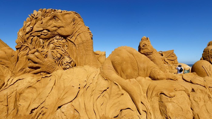 A visitor walks between sculptures during the Sand Sculpture Festival 