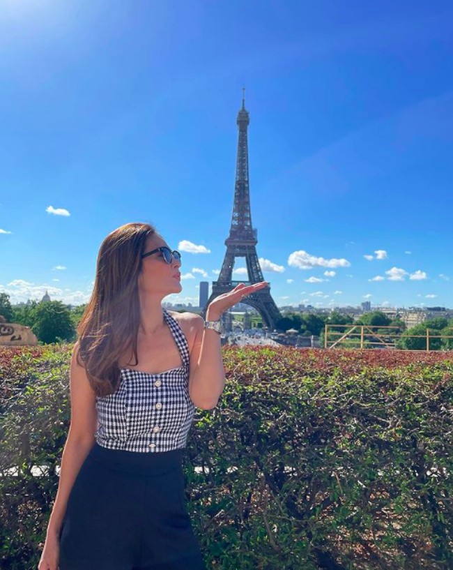 Potret Cut Tari dengan latar belakang Menara Eiffel. Istri dari aktor Richard Kevin itu tampil elegan menggunakan atasan tanpa lengan bermotif houndstooth. Foto: dok. Instagram/@cuttaryofficial