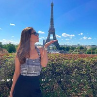 Potret Cut Tari dengan latar belakang Menara Eiffel. Istri dari aktor Richard Kevin itu tampil elegan menggunakan atasan tanpa lengan bermotif houndstooth. Foto: dok. Instagram/@cuttaryofficial