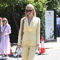 Sosialita Poppy Delevingne pun tak melewatkan final Wimbledon 2022. Ia menebar pesonanya dengan setelan kuning yang cerah, berikut sandal heels kulit dan tas senada. (Foto: GC Images/Neil Mockford)
