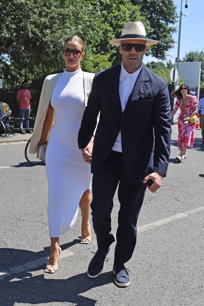 Final Wimbledon dimanfaatkan pasangan selebriti Jason Statham dan Rosie Huntington Whiteley untuk berkencan. Rosie tampil elegan dengan gaun putih dan blazer yang disampirkan di bahu. Sementar itu, Jason menyelaraskannya dengan polo shirt putih yang dipadu blazer navy dan celana panjang senada. Tidak ketinggalan topi panama dan kacamata hitam. (Foto: GC Images/Neil Mockford)