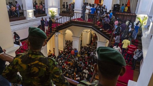 Army officers stand guard as people throng President Gotabaya Rajapaksa’s official residence for the second day after it was stormed in Colombo, Sri Lanka, Monday, July 11, 2022. Sri Lanka is in a political vacuum for a second day Monday with opposition leaders yet to agree on who should replace its roundly rejected leaders, whose residences are occupied by protesters, angry over the countrys economic woes. (AP Photo/Rafiq Maqbool)