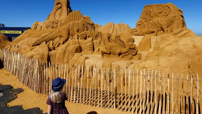 A visitor walks between sculptures during the Sand Sculpture Festival 