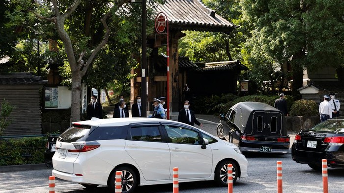 Momen Sang Istri Antar Jenazah Shinzo Abe ke Tempat Penghormatan Terakhir A vehicle believed to be carrying the body of late former Japanese Prime Minister Shinzo Abe, who was shot while campaigning for a parliamentary election, arrives at Zojoji-temple where his vigil and funeral will be held, in Tokyo, Japan July 11, 2022. REUTERS/Issei Kato
