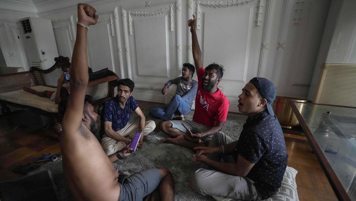 Protesters stay and play cards in prime minister's official residence a day after it was stormed in Colombo, Sri Lanka, Sunday, July 10, 2022. Sri Lanka’s president and prime minister agreed to resign Saturday after the country’s most chaotic day in months of political turmoil, with protesters storming both officials’ homes and setting fire to one of the buildings in a rage over the nation's severe economic crisis. (AP Photo/Eranga Jayawardena)
