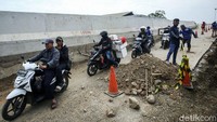 Warga yang melintas harus bergantian dengan keluar masuknya alat berat.