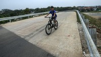 Seorang anak bermain sepeda di proyek overpass Sumberjaya.