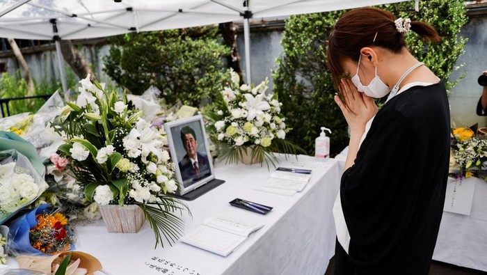 Pelayat Shinzo Abe Terus Berdatangan Beri Penghormatan Terakhir A portrait photo of late former Japanese Prime Minister Shinzo Abe, who was shot while campaigning for a parliamentary election, is placed on an altar as a mourner bows, at the Liberal Democratic Party (LDP) headquarters, in Tokyo, Japan July 11, 2022. REUTERS/Issei Kato